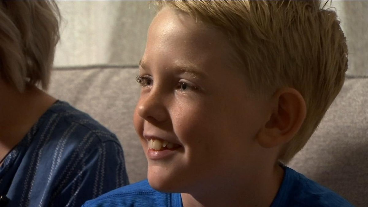 A young boy smiling in soft window light